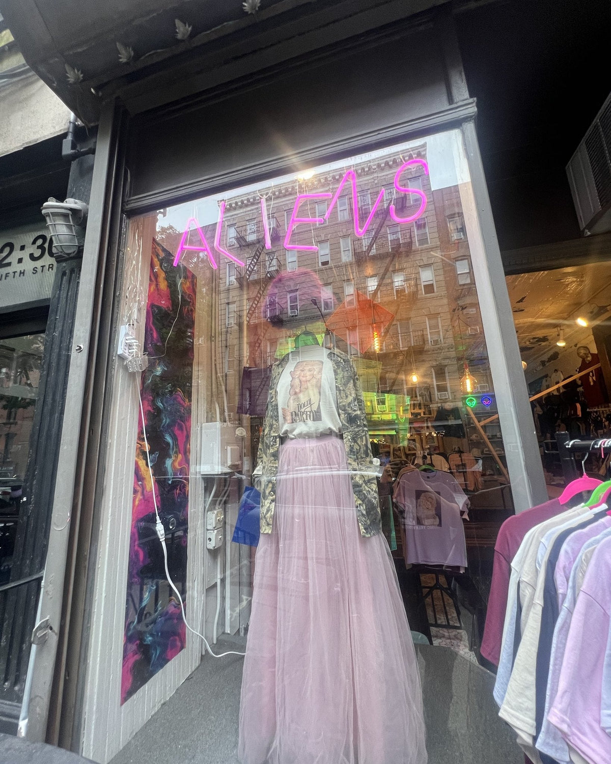 Storefront of Aliens of Brooklyn at 304 E 5th St, East Village, with the pink ALIENS neon sign