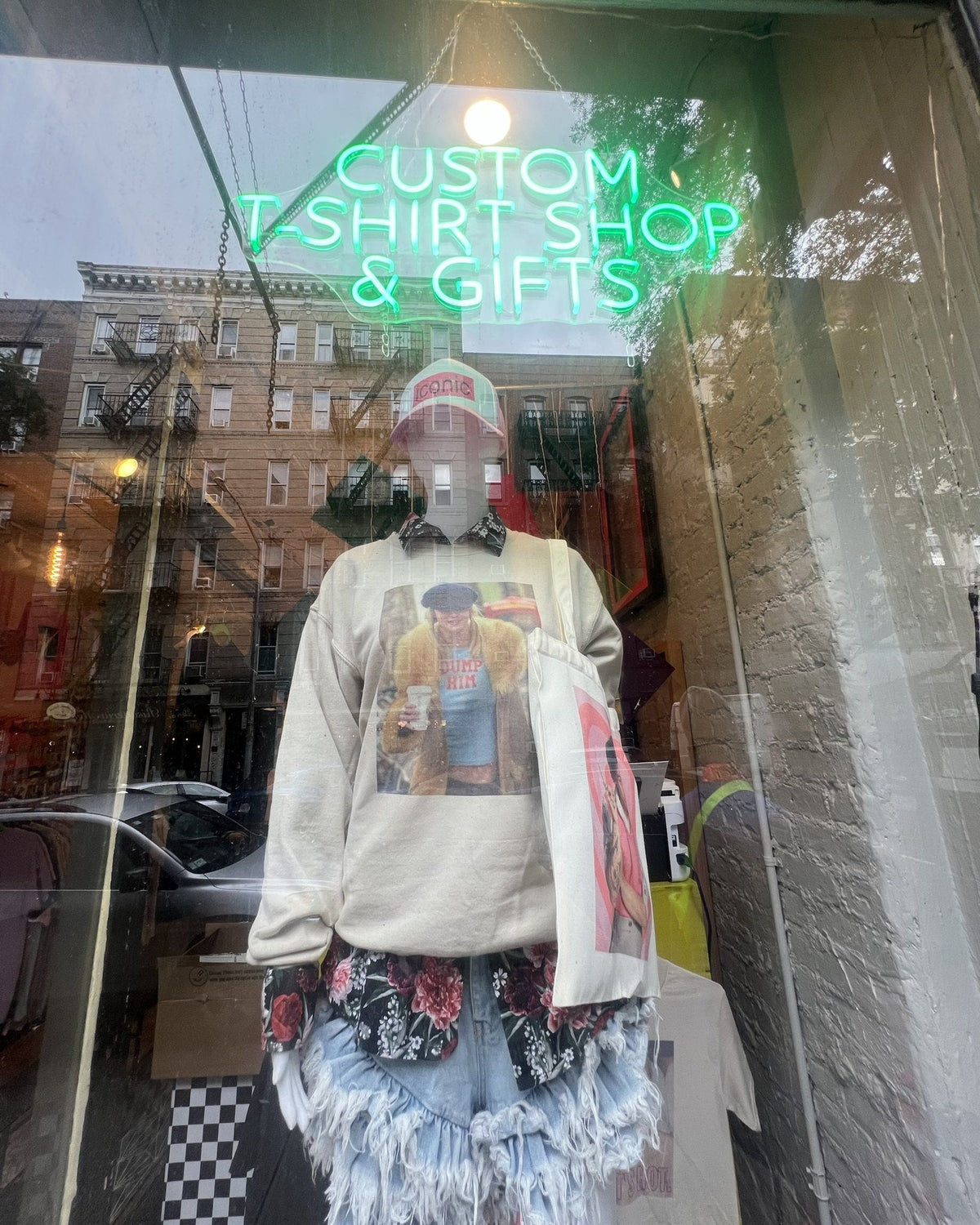 Custom T-shirt Shop and Gifts neon sign in the window at Aliens of Brooklyn, 304 E 5th St, East Village